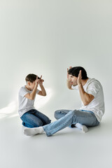 A father and son sit on the floor, playfully engaging in a lighthearted game.