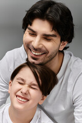 Obraz premium A father and son share a joyful moment, both laughing heartily.
