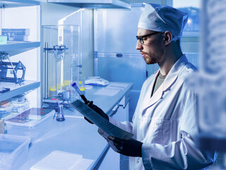 Man doctor. Flask of blood in hands of doctor. Medic performs genetic analysis. Doctor in white...