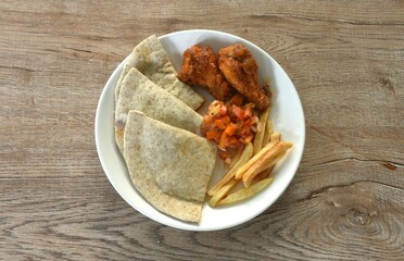 Quesadilla Mexican pizza stuffing mashed spicy chicken with French fries and barbecue buffalos wing topping sour salad on plate