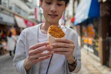 コロッケを食べ歩きする男性