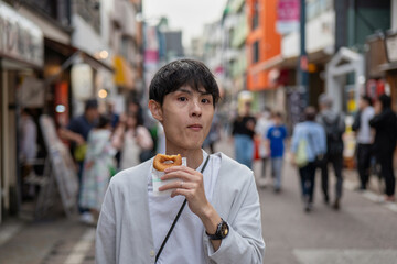 ドーナツを食べ歩きする男性