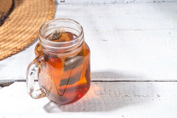 Sun Tea in mason jar, trendy cold sweet sun brew tea drink on wooden table