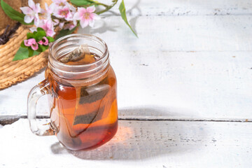 Sun Tea in mason jar, trendy cold sweet sun brew tea drink on wooden table