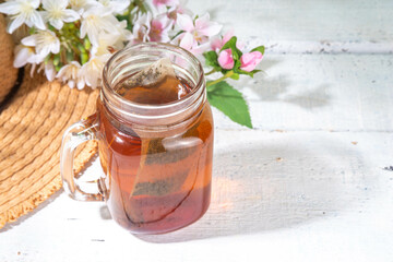 Sun Tea in mason jar, trendy cold sweet sun brew tea drink on wooden table