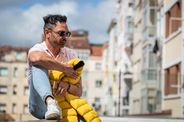 man with sunglasses on the street outdoors with mobile phone