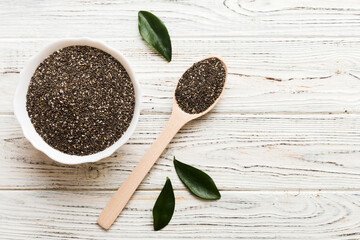 Chia seeds in bowl and spoon on colored background. Healthy Salvia hispanica in small bowl. Healthy superfood