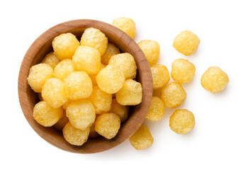 Corn balls in a wooden plate and scattered on a white background. Top view