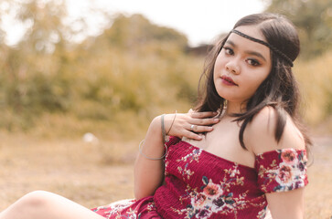 Young chubby Asian woman in boho fashion outdoors