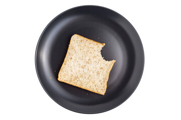 slice of plain bread on black plate that has been partially eaten, isolated on white background