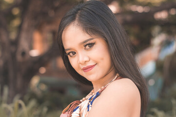 Fototapeta premium Young Asian woman in boho fashion smiling outdoors