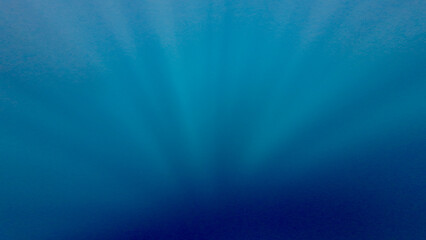 Underwater world background. Sun rays in the water column. Background rays of the sun underwater. Texture of the water column. The rays of the sun penetrate deep into the abyss.
