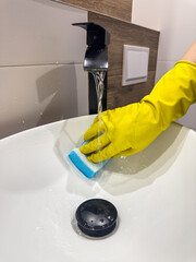 woman washing or wipes the sink in the bathroom