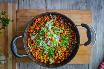Indian Aloo(Potato) Curry with fried peas and ground nuts. The curry is garnished with freshly chopped cabbage and coriander.