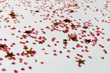 Gold colored stars and crystals confetti on a blue background. Glowing texture.