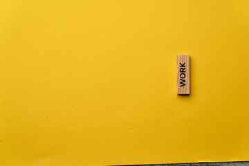 a yellow warm background without shadows wooden cubes with black letters laid out word work