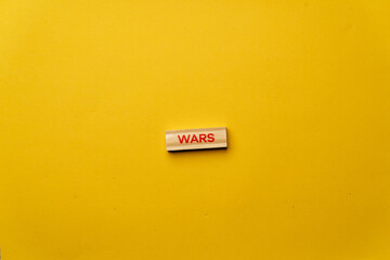 a yellow warm background without shadows wooden cubes with red letters laid out word wars