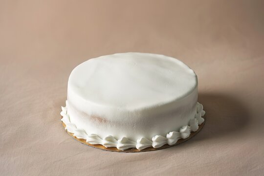 Plain white iced cake on a neutral background, ready for decoration.