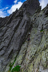 A gentle rocky slope with rock climbers on a summer day in Poland