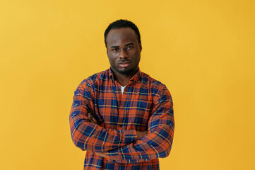 Obraz premium Standing and posing. Black man is in the studio against yellow background