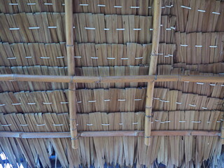 View from the southern side of a traditional thatched roof in a rural village. Use large bamboo trees instead of beams and pillars. That thatched roof can be sunproof and rainproof. And good ventilati