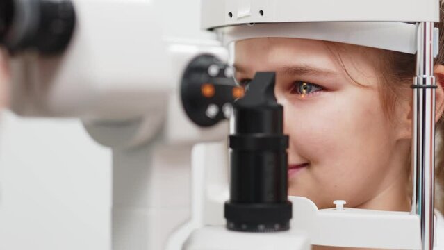 Examination of the child using a slit lamp. Microscope and focused light source. A device for high-precision examination of the eye to determine the condition of the lens.