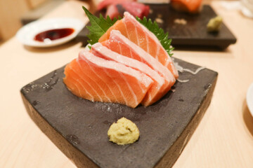 close up of Japanese salmon sashimi fish seafood on a grey stone plate