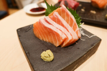 close up of Japanese salmon sashimi fish seafood on a grey stone plate