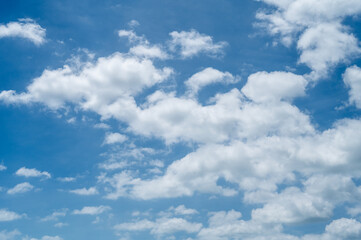 sky with scattered clouds It's a clear day. There are fluffy white clouds. Contrasting with the blue background