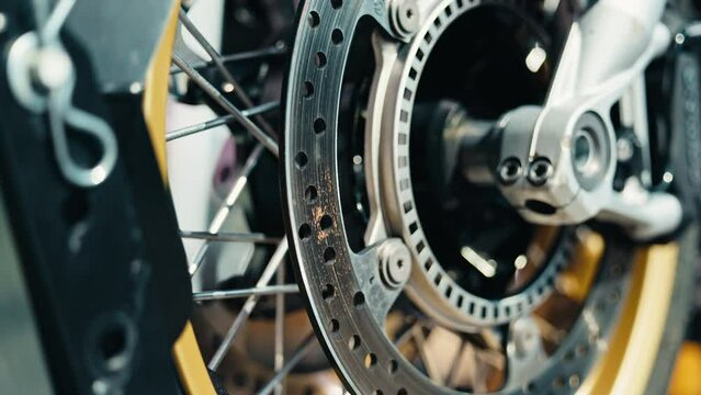 Slow motion closeup of a motorcycle disc brake system, showcasing precision engineering and parts in action