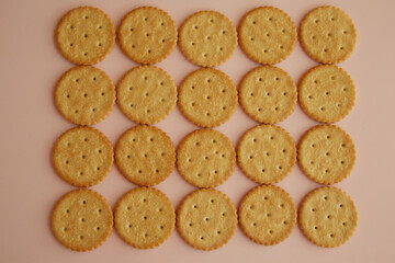 Saltine crackers on pink background closeup, cookies on table, fresh cookies, top view