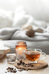 Still life with a cup of tea, books and a candle in a candlestick.