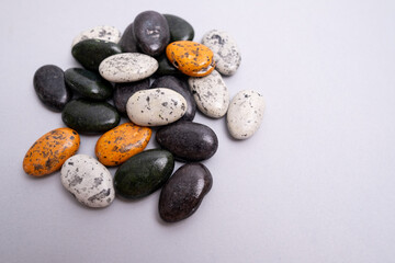Multi-colored colored stones pebbles on a colored background. Background for banner, backdrop or texture