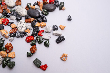 Multi-colored colored stones pebbles on a colored background. Background for banner, backdrop or texture