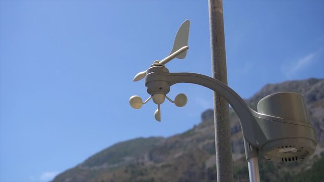 Slow motion, anemometer rotating at a home weather station, on a windy day