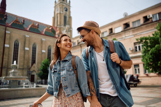 Young happy couple of travelers on town square.