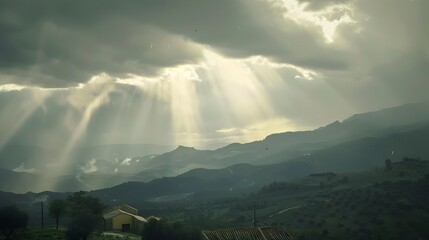 Dramatic Sunlight Breaking Through Moody Cloudy Sky Over Lush Mountain Landscape