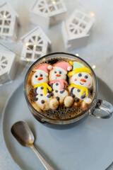 Cup of coffee with marshmallows. Marshmallow snowman in a Santa Claus hat. Winter drink. Christmas sweet food. Top view.