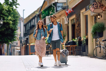 Young happy couple walking through  town while enjoying in summer trip.