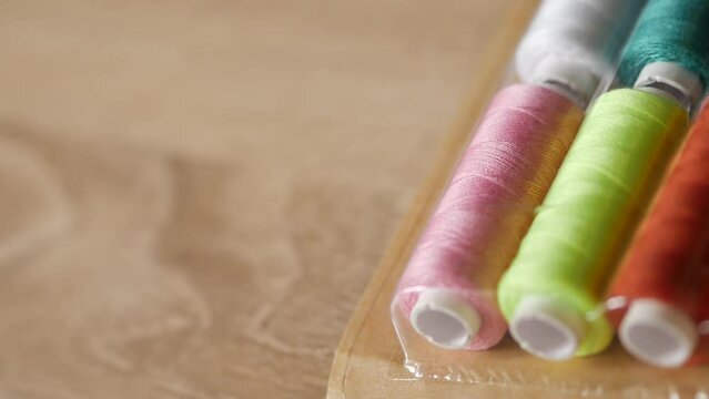 Multicolored sewing threads on paper bobbins and spools in blister packs. Threads for needlework, hobbies and recreation. Necessary item for every family. Materials for clothing repair and embroidery