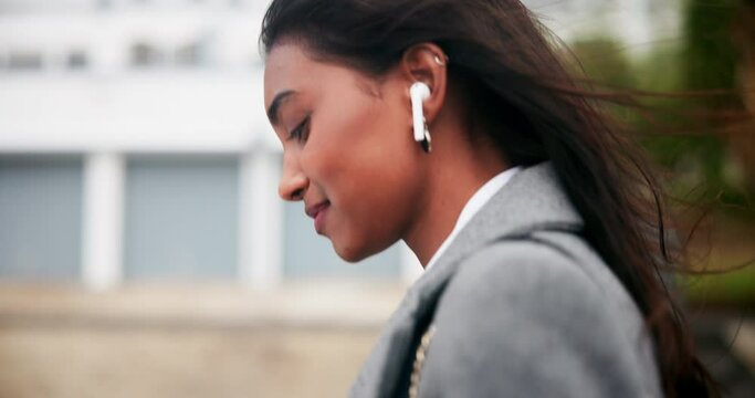 Indian woman, earphones and cellphone or city walk as financial broker for investment podcast, commute or online. Businessperson, wind and urban downtown or streaming radio, corporate or professional