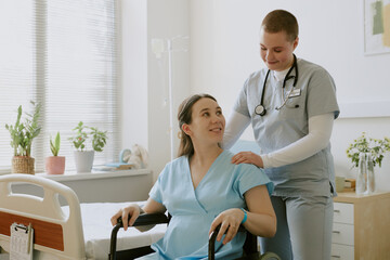 Nurse comforting pregnant patient while she sitting in wheelchair and getting ready for labor