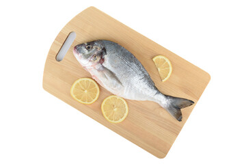 Slices of lemon and shredded and scaled dorada fish on cutting board.