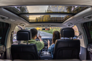 Man and woman traveling in car, sitting in car driving to travel destination.