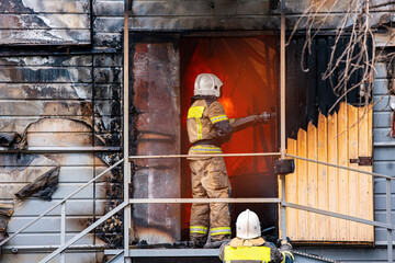 Fire incident in building. Action photo fireman team extinguishes burn with hose water