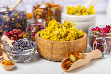 Assortment of dry herbal and berry tea on a wooden background. Tea party concept. medicinal herbs. Healing herbs.Alternative medicine.Linden, calendula, cornflowers, marigold, tansy, tea rose.