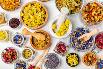 Assortment of dry herbal and berry tea on a wooden background. Tea party concept. medicinal herbs. Healing herbs.Alternative medicine.Linden, calendula, cornflowers, marigold, tansy, tea rose.