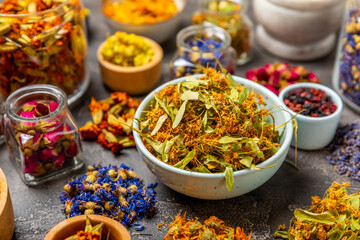 Assortment of dry herbal and berry tea on a wooden background. Tea party concept. medicinal herbs. Healing herbs.Alternative medicine.Linden, calendula, cornflowers, marigold, tansy, tea rose.