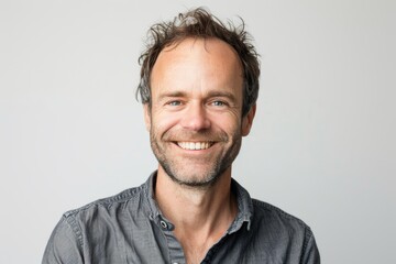 Fototapeta premium Portrait of a glad caucasian man in his 30s smiling at the camera while standing against white background