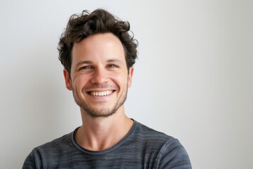 Obraz premium Portrait of a glad caucasian man in his 30s smiling at the camera in white background